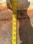 A measuring tape laid out flat on a rusted metal surface with measurements visible up to 60 inches