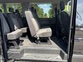 Interior view of a 2025 Ford Transit T-350 showing rows of gray upholstered seats with adjustable headrests in a spacious cabin area