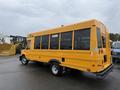 A yellow 2021 Ford Econoline with multiple windows and a rear door, designed for passenger transport