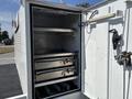 A 2017 Ford F-550 with an open compartment displaying stacked metal trays inside