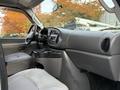 Interior view of a 2008 Ford Econoline showcasing the dashboard and front passenger space with cup holders and a stereo system
