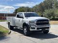 A 2021 RAM 5500 truck with a white exterior and utility bed parked on a driveway