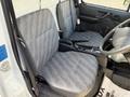 Interior view of a 2008 Suzuki Carry showing two grey fabric seats with a patterned design and a simple dashboard area