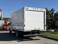 A 2019 Ford E-450 box truck with a plain white exterior and a flat rear loading dock