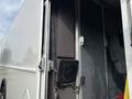 A 2018 Ford Econoline with an open side door showing interior seating and compartments