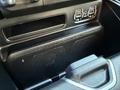 Close-up of a storage compartment in a 2023 RAM 3500 featuring wireless charging pads and auxiliary ports