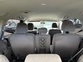 Interior view of a 2014 Honda Odyssey showing the back seats and center console with three rows of seating in a light gray fabric