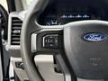 A close-up view of the steering wheel of a 2019 Ford F-350 SD showing the Ford logo and controls on the wheel