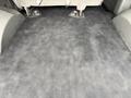 A 2004 Chevrolet Express with a clean and empty interior floor space showing gray carpeting and no visible items or seats in the foreground
