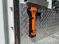 An orange flashlight attached to a metallic surface with a diamond plate pattern