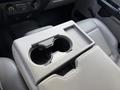 A close-up of the center console in a 2020 Ford F-550 featuring a two-cup holder and a storage compartment