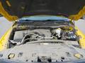 A 2015 RAM 1500 with the hood raised revealing a dirty engine compartment showcasing the engine components and battery