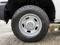 Close-up of a 2015 Ford F-350 SD wheel featuring a silver steel rim and an all-terrain tire with pronounced treads