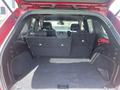 The interior of a 2015 Jeep Grand Cherokee with the rear seats folded down showcasing a spacious cargo area