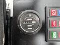A close-up view of a black hour meter displaying 487.1 hours on a quartz timer with adjacent buttons labeled for various functions