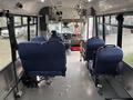 Interior view of a 2021 Ford Transit-350 showing driver and passenger seats with a blue fabric covering and an open space for movement