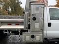 A 2015 Ford F-450 with a metallic toolbox attached to the side featuring multiple vents and a lockable door