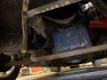 A 1968 Ford Mustang engine viewed from underneath showing various components including the oil filter and blue engine block