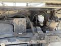 A 2012 Ford Econoline engine compartment showing various components including hoses wires and liquid reservoirs