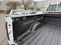 The image shows the bed of a 2015 GMC Sierra 1500 with a metal bed railing and a textured rubber mat inside