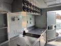 Interior of a 2020 Freightliner MT45 food truck featuring stainless steel countertops equipment controls and a row of vents along the wall