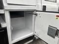 A 2014 Ford F-550 truck with an open storage compartment and a metal handle for access