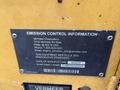 A close-up view of an emission control information label from a 2014 Vermeer Corporation Sweep Stump Cutter displaying the manufacturer's details and contact information