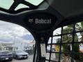Interior view of a 2017 Bobcat T740 with a black overhead panel displaying the Bobcat logo and a key ignition system visible
