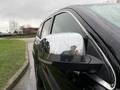 A black 2019 Jeep Grand Cherokee with a shiny side mirror reflecting light and displaying a water droplet covered surface