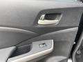 Interior door panel of a 2014 Honda CR-V featuring a handle and a window control switch