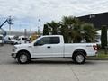 A 2018 Ford F-150 pickup truck in white color with a standard bed and chrome wheels parked on a concrete surface
