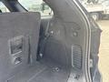 Interior view of a 2015 Dodge Durango showing the rear cargo area with dark carpeting and storage compartments
