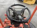 A close-up view of the steering wheel and control panel of a 2015 Kubota F3990 tractor with visible water droplets on the surface