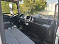 Interior dashboard of a 2012 Hino 338 featuring a large console with controls and gauges two front seats and a gear shift
