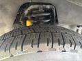 Close-up of a tire of a 2018 Ford Econoline showing detailed tread pattern and part of the suspension system visible above the tire