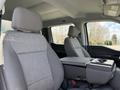 Two gray seats of a 2024 Ford F-550 with a center console visible between them