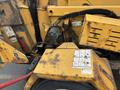 A yellow 2015 Vermeer Corporation BC1200XL wood chipper with visible wear and tear showing controls and safety labels