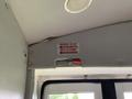 Interior view of a 2015 Chevrolet Express showing an emergency release sign mounted on the ceiling above the door