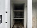 Interior view of a 2015 Freightliner M2 featuring metal shelves inside a cargo area