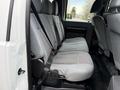The interior of a 2016 Ford F-550 Super Duty featuring gray cloth seats in the rear with seat belts visible