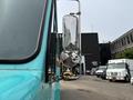 A 2020 Freightliner MT45 truck with a turquoise exterior and a side mirror reflecting its surroundings