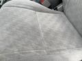 A gray fabric car seat from a 2004 Toyota Tacoma showing a textured pattern with a visible seam and slight wear