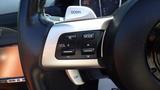 Close-up of the steering wheel controls of a 2007 Mazda Miata featuring buttons for volume and mode settings