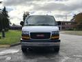 2023 GMC Savana van with a white exterior and chrome grille featuring the GMC logo in red
