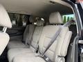 Interior view of a 2014 Honda Odyssey showing three rows of beige cloth seats with seatbelts fastened