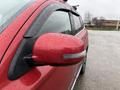 A 2016 Mitsubishi Outlander with a red exterior and a side mirror featuring a turn signal indicator covered in rain droplets
