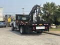 A 2009 Ford F-450 Super Duty pickup truck with a flatbed and a mounted hydraulic crane in the rear