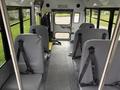 Interior view of a 2013 Chevrolet Express bus featuring gray bench seats with safety straps and an emergency exit door at the rear