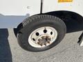 Close-up of a worn 2012 Ford Econoline tire with visible rusted lug nuts and a tread pattern indicating use