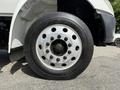 Close-up of a Goodyear tire mounted on a silver wheel with multiple lug nuts on a 2011 International 4300 truck